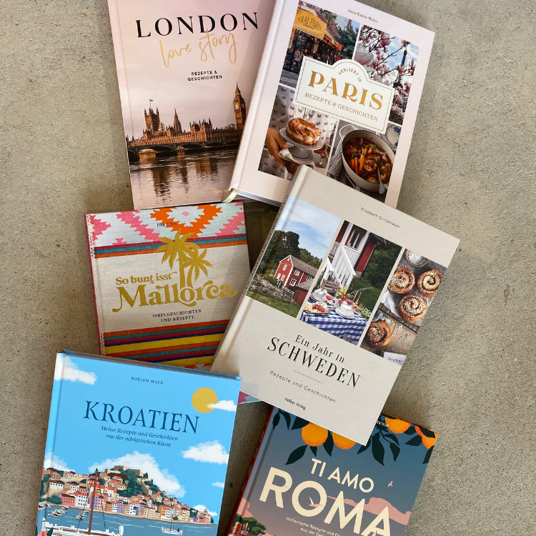 Über uns - Verlage - Hölker Verlag - Kochbücher Foto von mehreren Kochbüchern, die übereinander auf einem Steinboden liegen. Von oben fotografiert