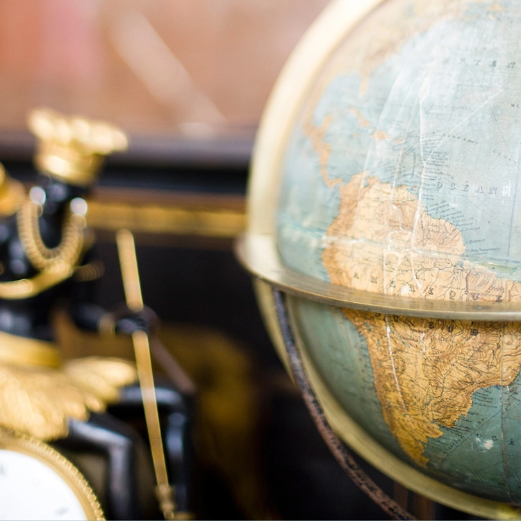 Anzeigebild Export Globus nimmt die Hälfte des Bildes ein, unscharf links eine antike Uhr zu sehen