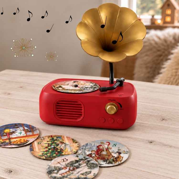 Kleines rotes Grammophon mit Schallplatten auf einem Tisch.